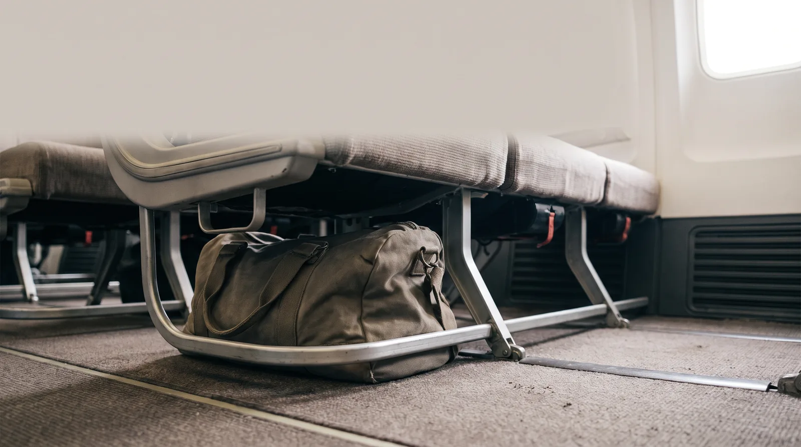 Sac de cabine glissé sous le siège d'un avion